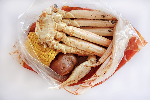 seafood boil bag with spices, crab legs, corn